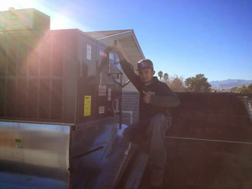 HVAC technician performing AC Tune-Up on a rooftop unit in Gloucester Point